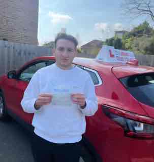 Successful driving student standing with certificate beside the AG Driving School car.